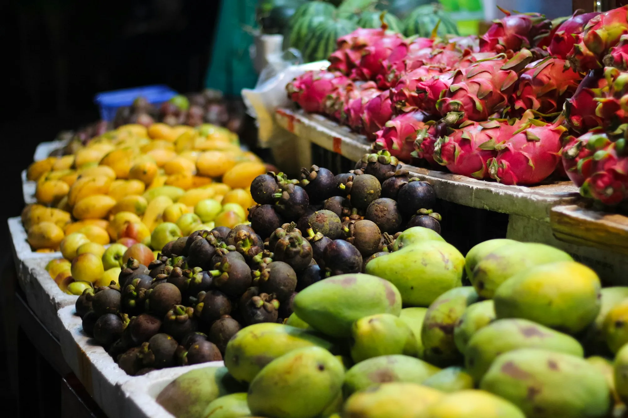 Mangoes, mangosteens and dragon fruit at a market stall
